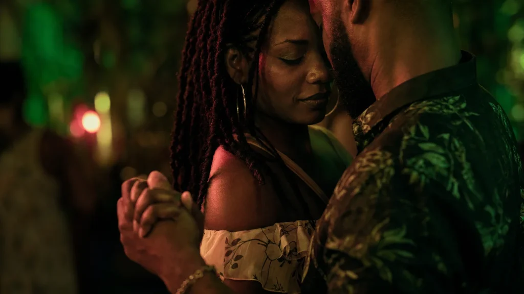A couple in a close, slow Gouyad embrace under low emerald and rose light.